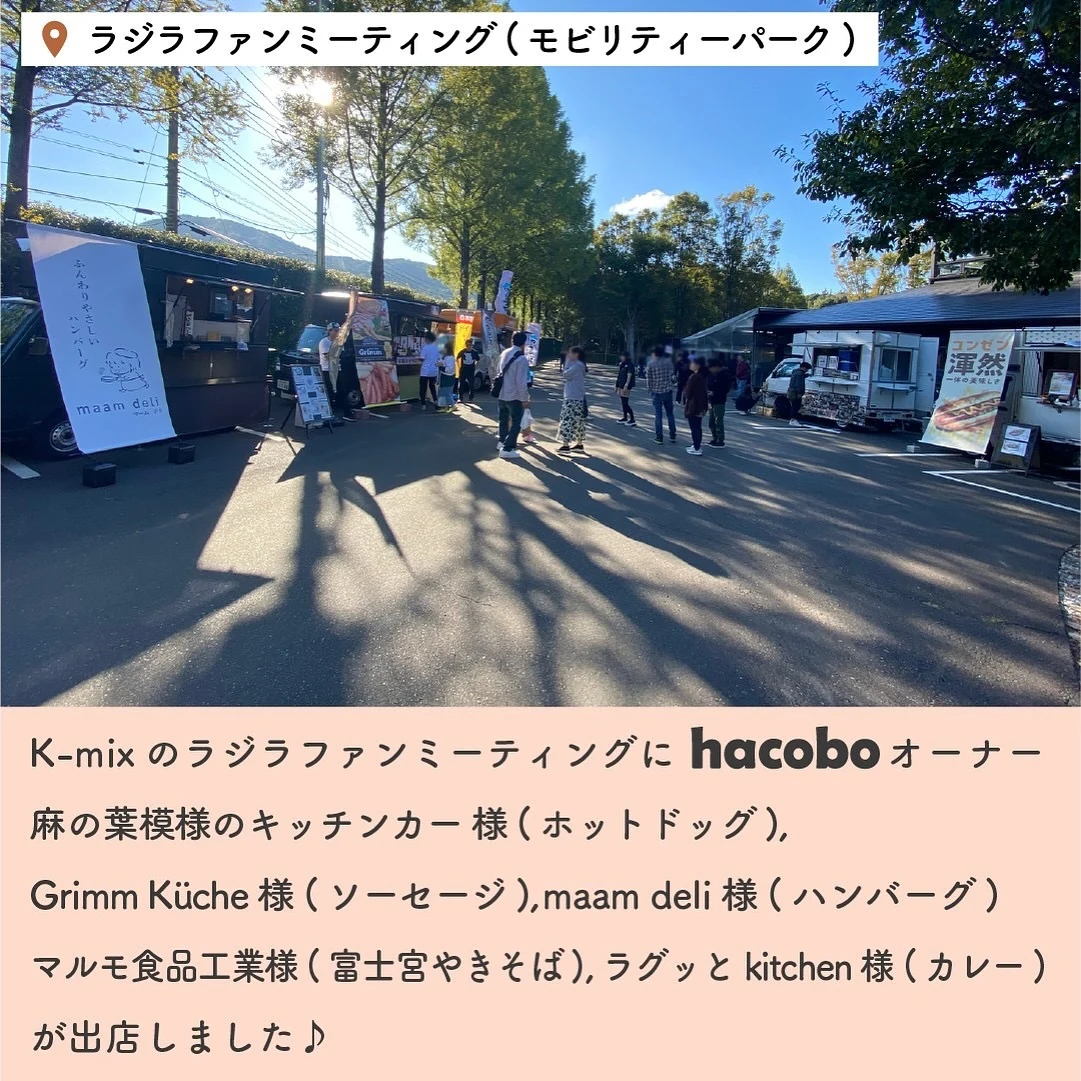木々のあるイベント会場に複数のキッチンカーと来場者が並ぶ