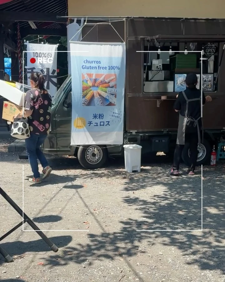 米粉チュロスののぼりを立てたキッチンカーの販売窓と来店客