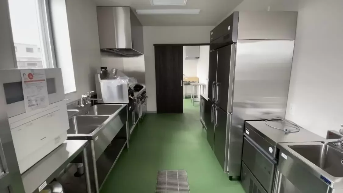 テストキッチンの内部全景（シンク・調理台・業務用冷蔵庫が並ぶ厨房）